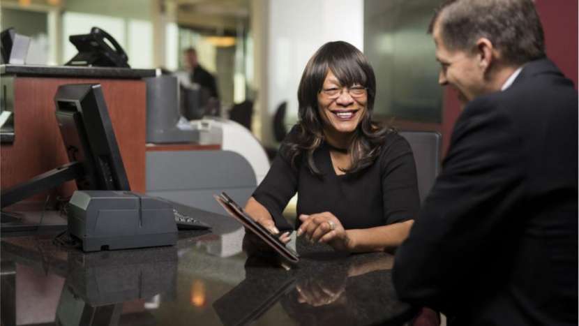 banker helping customer with a tablet