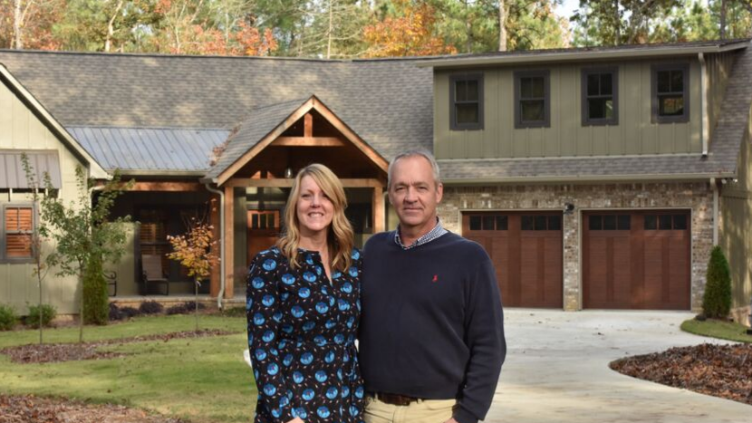 Couple standing in front of home