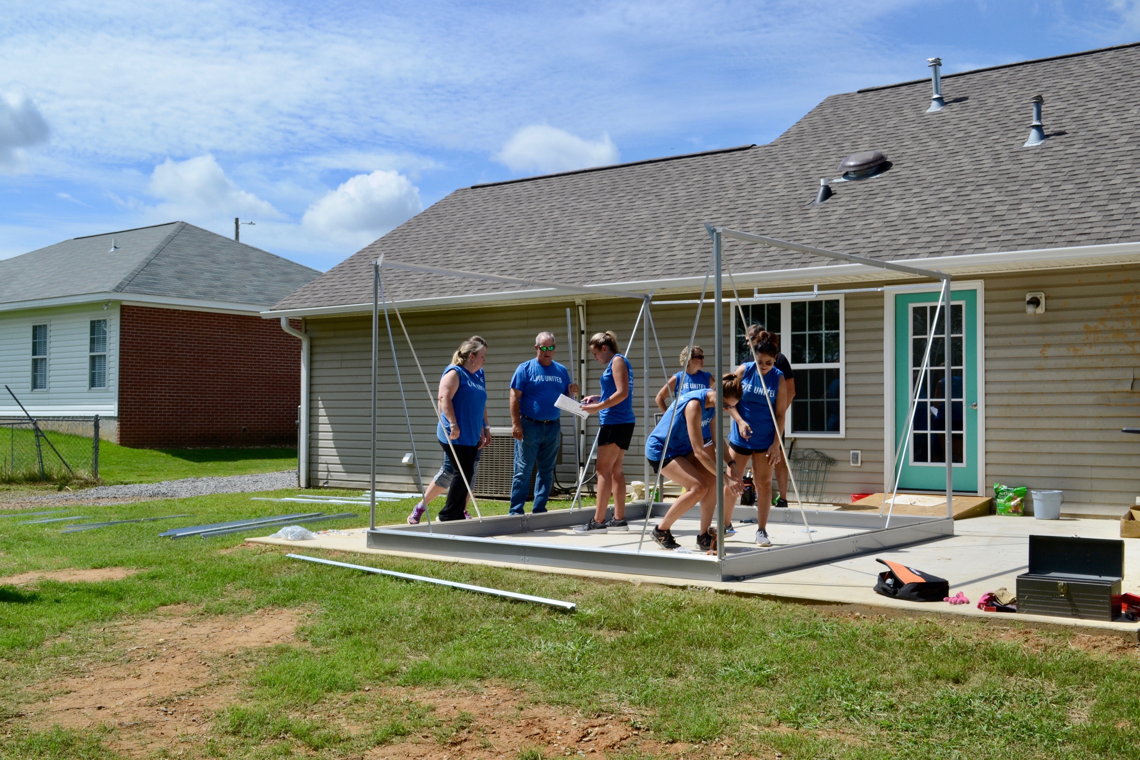 Volunteers from Peoples Bank building a greenhouse