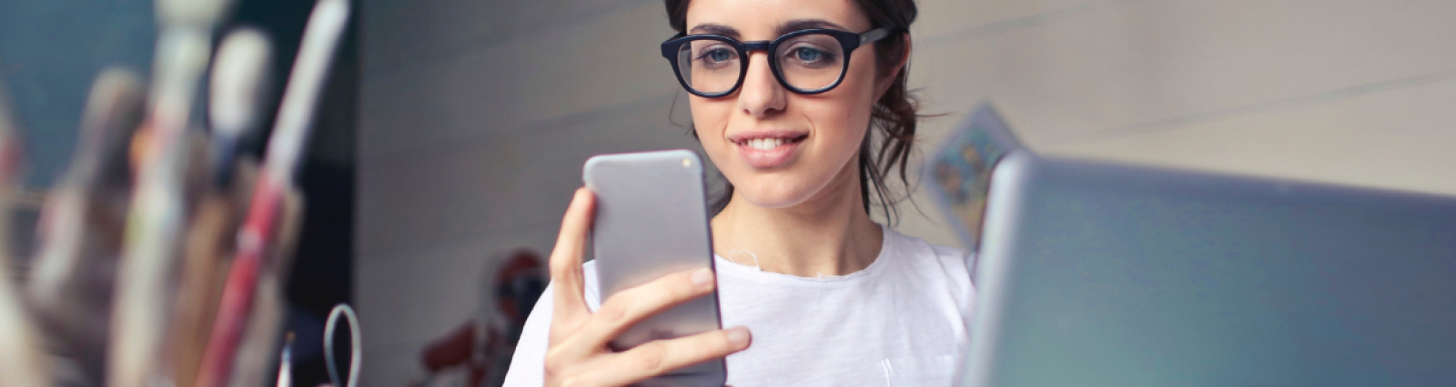 Peoples Pay - Woman with glasses smiling at phone