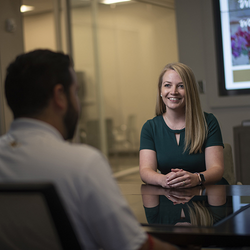 Woman sitting across the table from a man conversing.